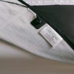 An Earthing® Grounding Mattress Cover - Super King Size with a grid pattern on one side, a solid black panel on the other, an earthing lead connection point, and a product label.