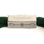 The EarthBand PEMF Bracelet from BeGrounded is a green rope bracelet with a silver clasp engraved EARTHBAND. It features metallic accents and a minimalist figure-eight design, offering a sleek and modern look.